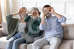 Overjoyed couple playing tricks fool with son at home.