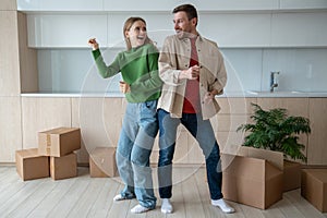 Overjoyed dancing man and woman move in new apartment happy about living together. Relocation