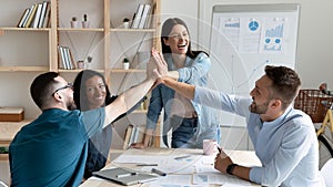 Overjoyed employees team giving high five, celebrating success