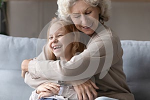 Overjoyed grandmother embrace playing with little granddaughter