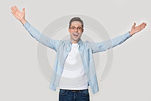 Overjoyed happy man standing with his hands wide open photo