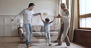 Overjoyed little child boy jumping with dad and grandfather.