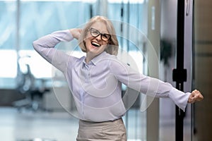 Overjoyed middle-aged businesswoman have fun celebrating work success