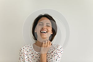 Overjoyed millennial female stand with closed eyes breaking into laughter