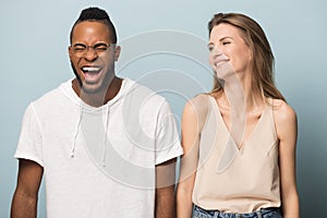 Overjoyed multiethnic couple laugh at funny joke together