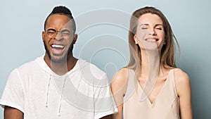 Overjoyed multiethnic man and woman laugh at funny joke