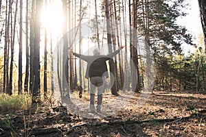 Overjoyed old man feeling freedom while traveling in forest during the autumn