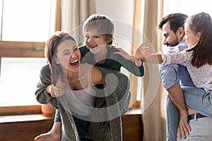 Overjoyed parents have fun playing with children