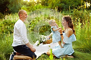 Overjoyed parents with young daughter having a picnic