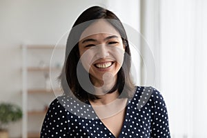 Overjoyed pretty asian woman look at camera with sincere laughter