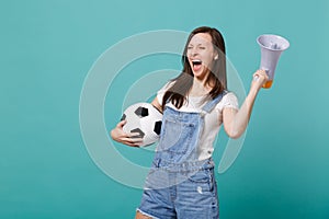 Overjoyed screaming young woman football fan support favorite team with soccer ball, megaphone isolated on blue