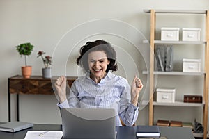 Overjoyed senior 60s woman celebrating online success.