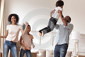 Overjoyed smiling black family celebrating moving in new house.