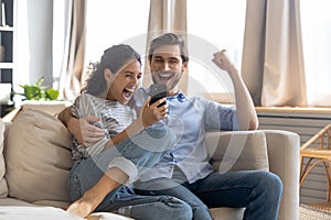 Overjoyed surprised young couple looking at phone screen