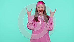 Overjoyed teen girl showing rock n roll gesture by hands, cool sign, shouting yeah with crazy face