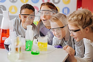 Overjoyed teenage students observing final stage of chemical experiment