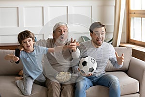 Overjoyed three generations of men watching match, supporting favorite team