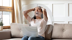 Overjoyed young asian ethnic woman reading email with unbelievable news.