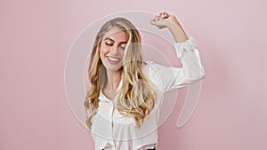 Overjoyed young blonde woman in casual shirt, confidently dancing to music, full of joy and cheerfulness, standing isolated over