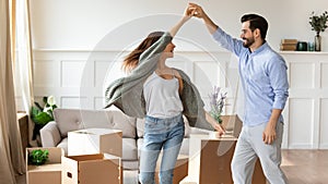Overjoyed couple dance have fun on moving day photo