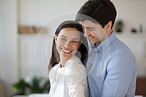 Overjoyed young couple hug showing care and affection