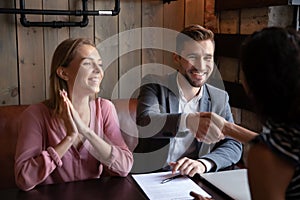 Overjoyed young couple making investment deal at meeting