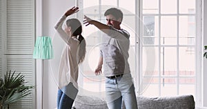 Overjoyed young just married couple dancing to energetic music