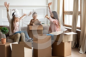 Overjoyed young parents play with little kids on moving day