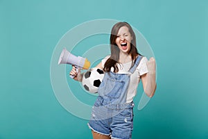 Overjoyed young woman football fan support favorite team with soccer ball megaphone doing winner gesture isolated on