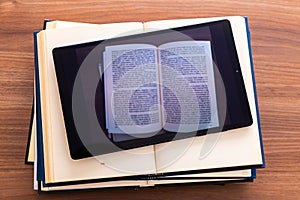 Overlapping open books, with a tablet on top. photo
