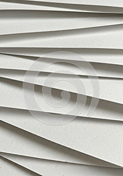 Overlapping sheets of textured white paper create a layered pattern, casting subtle