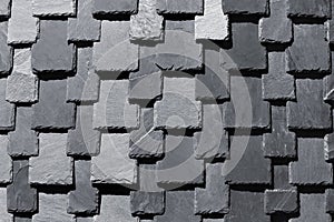 Overlapping stone slabs on a roof. Tiled shingle background