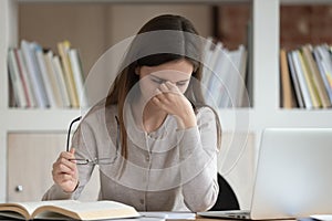 Overload young girl feeling fatigue, taking off glasses.