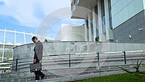 Overloaded businessman leaving office at and of week, depressed and overloaded