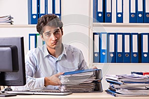 The overloaded busy employee with too much work and paperwork