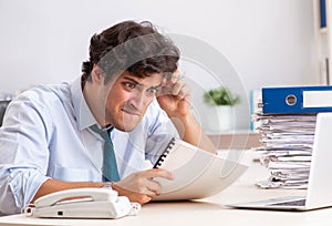 Overloaded busy employee with too much work and paperwork