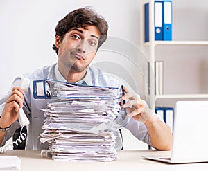 Overloaded busy employee with too much work and paperwork