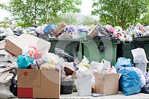 Overloaded dumpster, full garbage container, household garbage bin, trash can, heap of unsorted rubbish, pile of refuse, litter