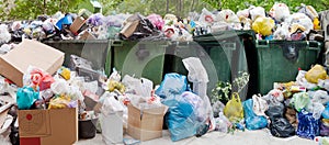 Overloaded dumpster, full garbage container, household garbage bin, trash can, heap of unsorted rubbish, pile of refuse, litter