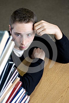 Overloaded Student Looking At Pile of Books