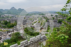 Overlook from stone wall to ancient town in mountains on cloudy