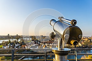 Overlooking view on the city with a binocular in the foreground