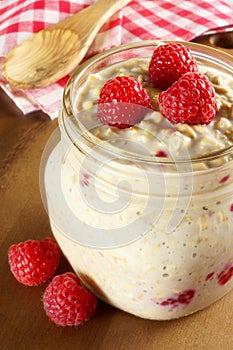 Overnight breakfast oats with raspberries in a mason jar photo