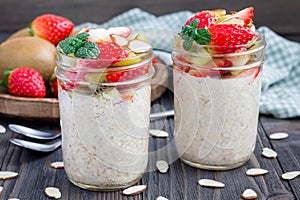 Overnight oatmeal with fresh strawberry and kiwi, garnished with sliced almond