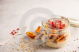 Overnight oatmeal with pomegranate, persimmon and hemp seeds, white background.