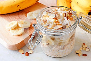 Overnight oats with bananas and nuts on white marble