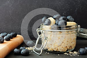 Overnight oats with blueberries and bananas against a dark background