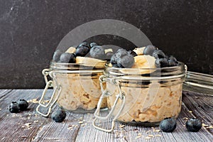 Overnight oats with blueberries and bananas on a dark background