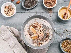Overnight oats in bowl and ingredients on gray wooden table
