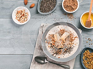 Overnight oats in bowl and ingredients on gray wooden table